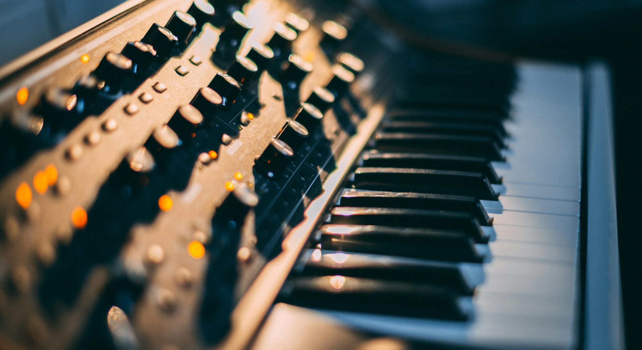 Detailed focus on a piano keyboard and control panel in a music studio setting.